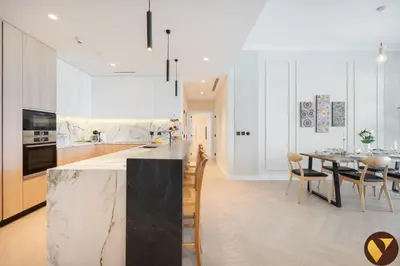 a kitchen and dining room with a table and chairs at Vogue Emirates Hills, Vida The Hills Residence near Marina and JBR, Three Bedroom Apartment with Balcony and Golf Club View, Access to all Amenities in Dubai