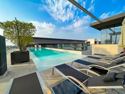a swimming pool on the roof of a building at Chic 2Bedroom And Maids Room Apartment Mins from Dubai Mall in Dubai