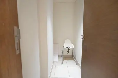 a white hallway with a white chair in a room at Spacious Two Bedroom with Maids room Near City Mall in Dubai