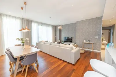 a living room with a white couch and a table at Spacious Two Bedroom with Maids room Near City Mall in Dubai
