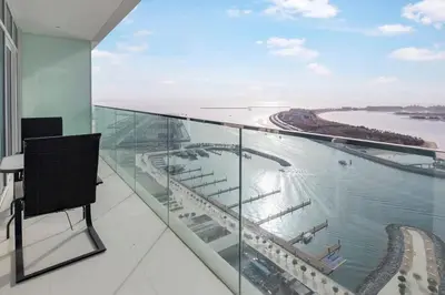a glass balcony with a view of the ocean at Elegant 1BR at Sunrise Bay with Stunning Palm View in Dubai
