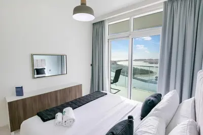 a bedroom with a bed and a large window at Elegant 1BR at Sunrise Bay with Stunning Palm View in Dubai