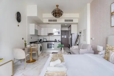 a living room with a bed and a kitchen at GuestReady - Studio | Stunning Burj Khalifa View in Dubai