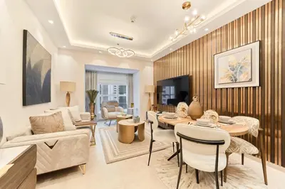 a living room with a couch and a table and chairs at Bright 1BR Apartment in Elite Residence Marina in Dubai