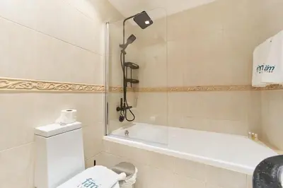 a bathroom with a tub and a toilet and a sink at Bright 1BR Apartment in Elite Residence Marina in Dubai
