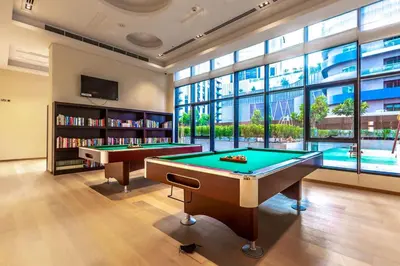 a billiard room with two pool tables and a tv at Urban 1BR Retreat RP Heights Near Dubai Mall in Dubai