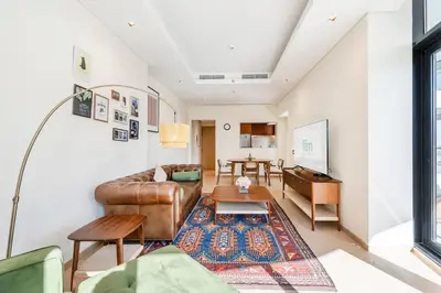 a living room with a leather couch and a table at Urban 1BR Retreat RP Heights Near Dubai Mall in Dubai