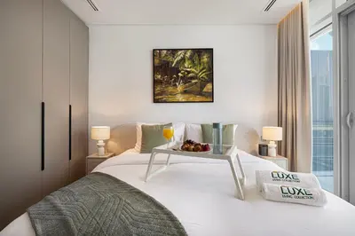 a bedroom with a bed with a tray of fruit on it at Burj Daman By Luxe Living - Future Museum & Emirates Towers Views in Dubai