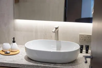 a bathroom with a white sink on a counter at Burj Daman By Luxe Living - Future Museum & Emirates Towers Views in Dubai