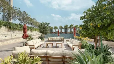 a patio with couches and tables and umbrellas at Burj Daman By Luxe Living - Future Museum & Emirates Towers Views in Dubai