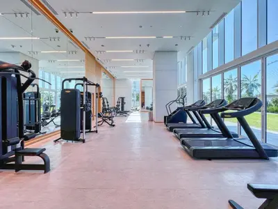 a gym with rows of treadmills and machines at La Vie Majestic 2BDR with Private Beach Access in Dubai