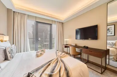 a hotel room with a bed and a desk and a television at Premium 2BR Address Opera Downtown Dubai in Dubai