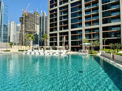 a swimming pool in front of a tall building at Skyline Escape 2 bedroom with Burj Khalifa View in Dubai