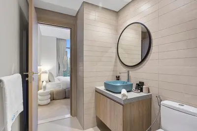 a bathroom with a blue sink and a mirror at Skyline Escape 2 bedroom with Burj Khalifa View in Dubai