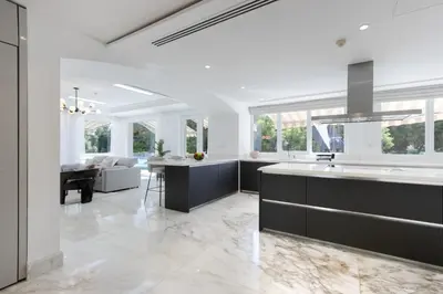 a kitchen with black cabinets and a living room at Exclusive Golf Villa 5BR with Pool and Game Room in Dubai