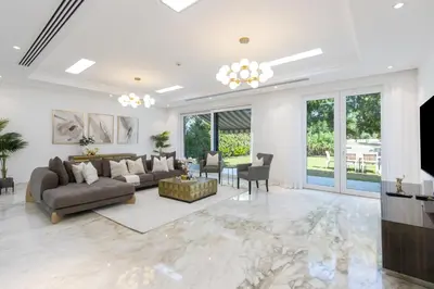 a living room with a couch and a tv at Exclusive Golf Villa 5BR with Pool and Game Room in Dubai