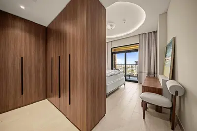 a bedroom with wooden cabinets and a bed with a window at Brand New Luxury 2BHK Apartment in Jadeel 2 MJL in Dubai