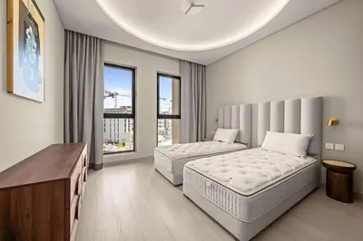 a bedroom with two beds and a large window at Brand New Luxury 2BHK Apartment in Jadeel 2 MJL in Dubai