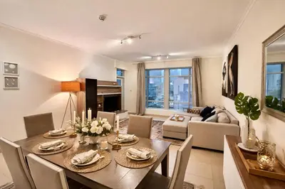a dining room and living room with a table and chairs at Luxury 1BR Apartment at Burj Views Tower C - Downtown in Dubai