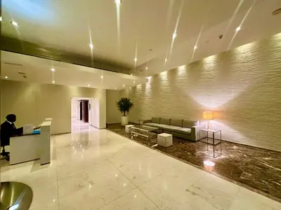 a man sitting at a desk in a lobby at Luxury 1BR Apartment at Burj Views Tower C - Downtown in Dubai