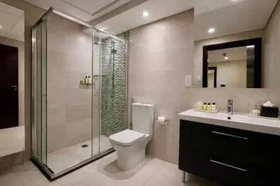 a bathroom with a shower and a toilet and a sink at Luxury 1BR Apartment at Burj Views Tower C - Downtown in Dubai