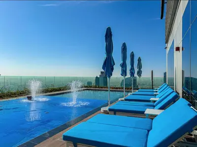 a row of blue lounge chairs next to a swimming pool at Morden 2BR With Full sea view -High floor in Dubai