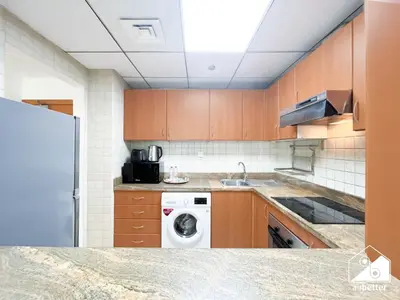 a kitchen with a washing machine and a washer at 1BR City Escape at Marina Residence Pool & Gym in Dubai