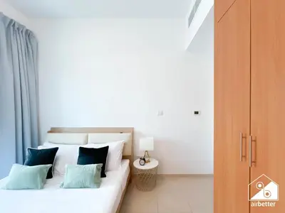 a bedroom with a bed with blue and white pillows at 1BR City Escape at Marina Residence Pool & Gym in Dubai