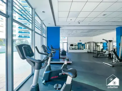 a gym with cardio equipment in a building at 1BR City Escape at Marina Residence Pool & Gym in Dubai