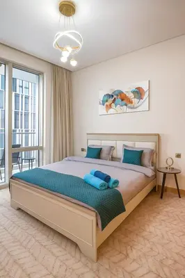 a bedroom with a large bed with blue pillows on it at Vida Dubai Mall - Luxury 1BR with Direct access to Dubai Mall in Dubai