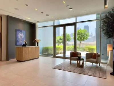 a lobby with two chairs and a desk and windows at Vida Dubai Mall - Luxury 1BR with Direct access to Dubai Mall in Dubai