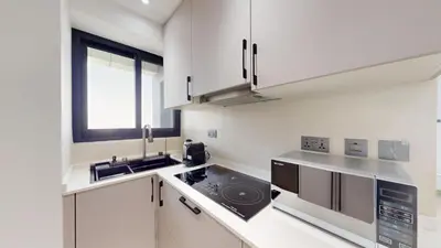 a white kitchen with a sink and a stove at Locations l Elegant 1 Bedroom l Skyline Views l Dubai Marina in Dubai