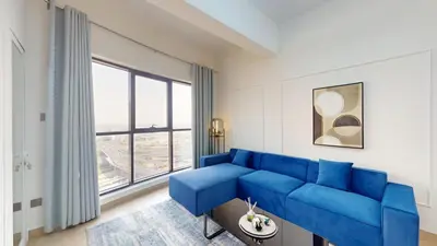a living room with a blue couch and a large window at Locations l Elegant 1 Bedroom l Skyline Views l Dubai Marina in Dubai