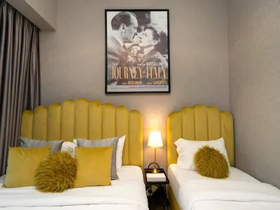 a bedroom with two beds with a movie poster on the wall at Fountain view Golden Era Cinema-Inspired 4BR APT in Dubai