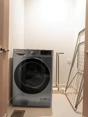 a washing machine sitting in the corner of a room at Fountain view Golden Era Cinema-Inspired 4BR APT in Dubai