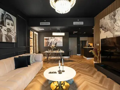a living room with a white couch and a table at Fountain view Golden Era Cinema-Inspired 4BR APT in Dubai