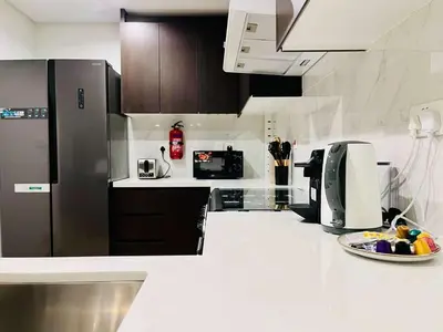 a kitchen with black appliances and a white counter top at Skyline 19 1 Residences in Dubai