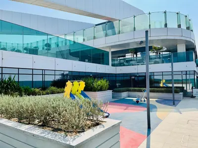 a large glass building with a playground in front of it at Skyline 19 1 Residences in Dubai