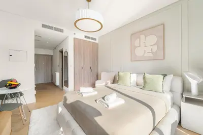 a white bedroom with a large bed in a room at VayK - Bright Studio Overlooking The Canal in Business Bay in Dubai