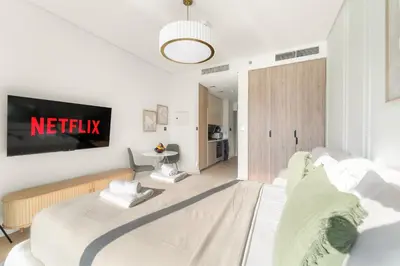 a bedroom with a bed and a tv on the wall at VayK - Bright Studio Overlooking The Canal in Business Bay in Dubai