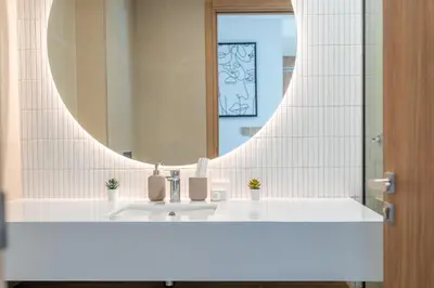 a bathroom with a sink and a mirror at Relaxing Studio with Balcony & Pool in Haven Tower in Dubai