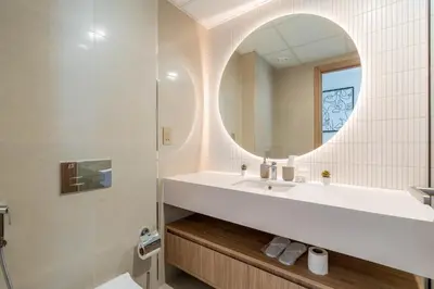 a bathroom with a sink and a mirror at Relaxing Studio with Balcony & Pool in Haven Tower in Dubai
