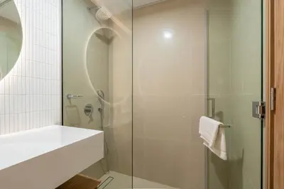 a bathroom with a glass shower and a sink at Relaxing Studio with Balcony & Pool in Haven Tower in Dubai