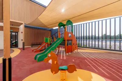 a room with a playground with a slide at Relaxing Studio with Balcony & Pool in Haven Tower in Dubai