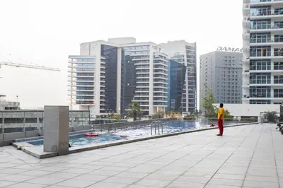 a man standing on the roof of a building at Stylish 2BR Oasis in Business Bay with Pool & Gym in Dubai