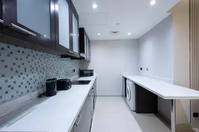 a kitchen with white counter tops and a dishwasher at Stylish 2BR Oasis in Business Bay with Pool & Gym in Dubai