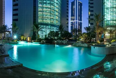 a large pool in the middle of a city at night at JBR High Floor 2BR Stunning Ain Dubai View in Dubai