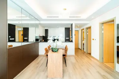 a kitchen and dining room with a wooden table at 2BR With Rooftop Pool Offering Burj Khalifa Views in Dubai