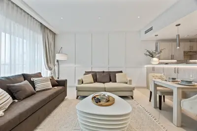 a living room with a couch and a table at Palm Jumeirah Sea-View Stay - Infinity Pool - Beach - Gym - Padel in Dubai