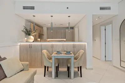 a dining room with a table and chairs in a kitchen at Palm Jumeirah Sea-View Stay - Infinity Pool - Beach - Gym - Padel in Dubai